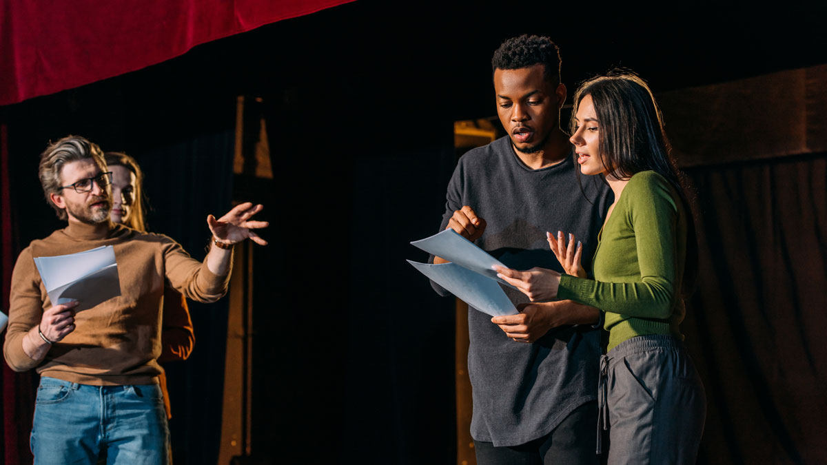 theater director, multicultural actors and actress rehearsing on stage