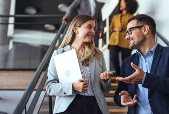 Colleagues Engaging in a Pleasant Discussion on Office Staircase