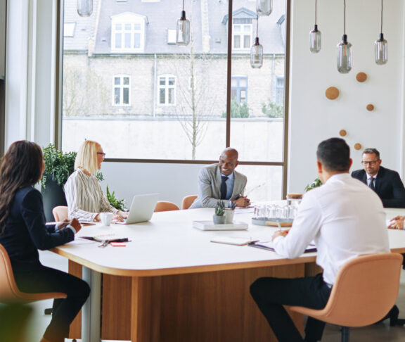 Smiling group of diverse businesspeople having a boardroom meeting together