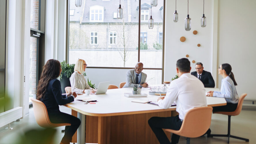 Smiling group of diverse businesspeople having a boardroom meeting together