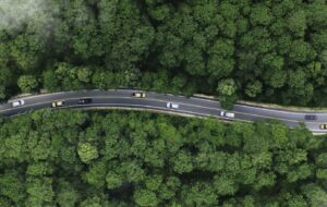 car on road midst forest and natural. Environmental friendly travel. Sustainable transportation and green logistic to Net zero carbon emission for Save earth.