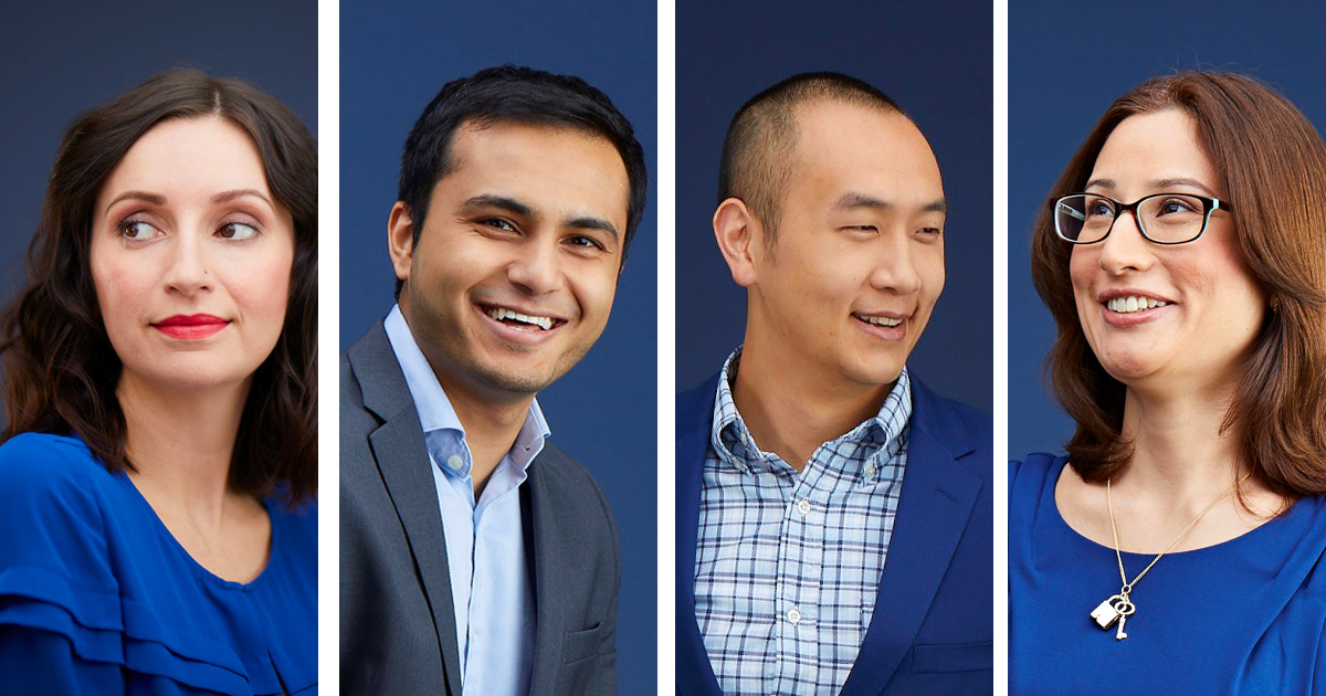 Four academics in blue, smiling