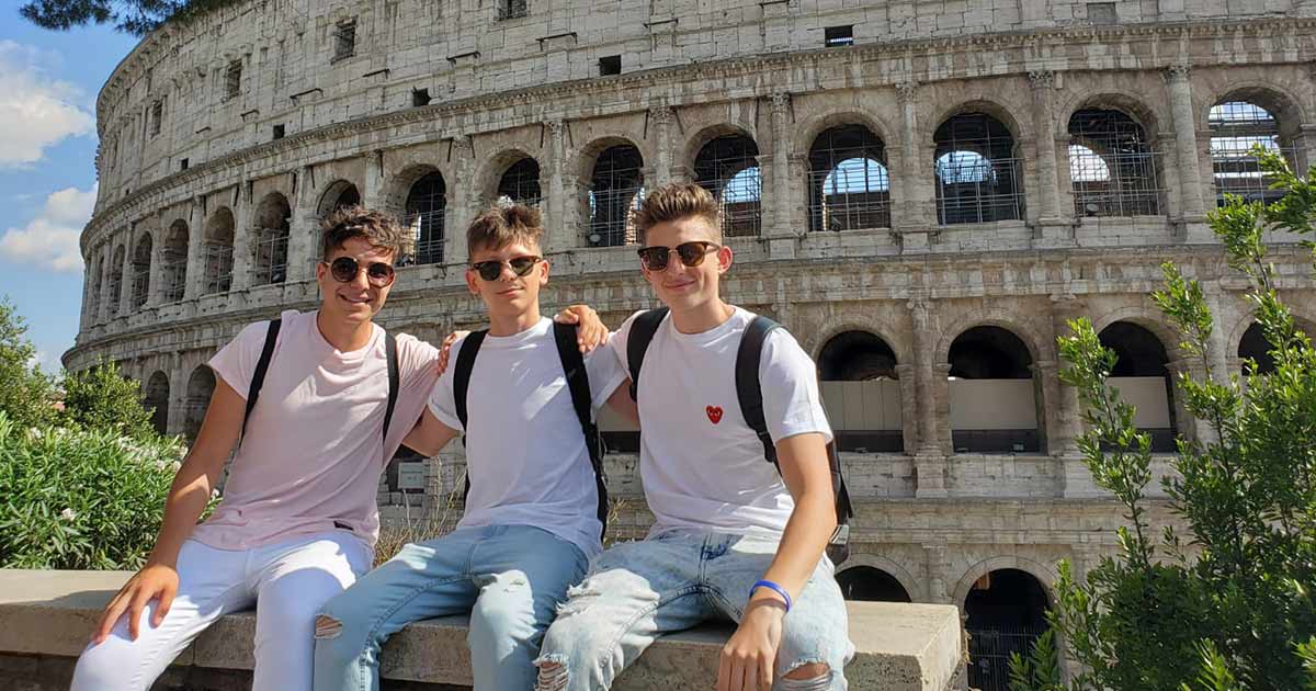 Three high school students in front of the Roman Colosseum