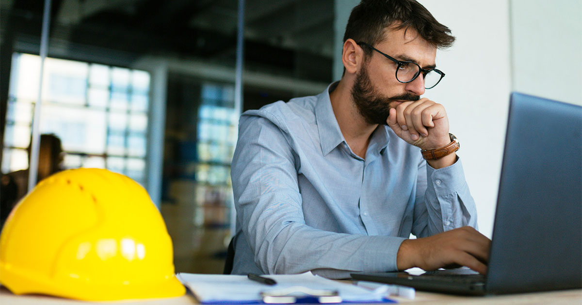 man with beard and glasses working on computer