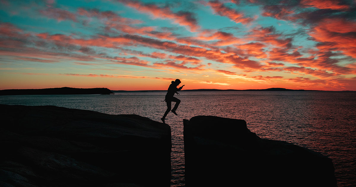 man jumping cliffs nature