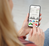 Frau überwacht Smart Meter-Messwerte auf dem Handy, Nahaufnahme