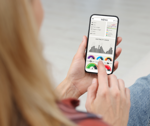 Frau überwacht Smart Meter-Messwerte auf dem Handy, Nahaufnahme