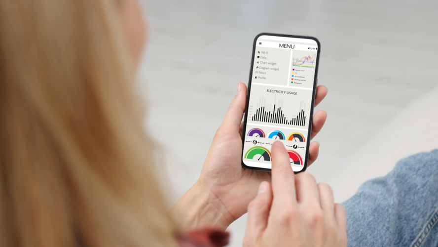Frau überwacht Smart Meter-Messwerte auf dem Handy, Nahaufnahme