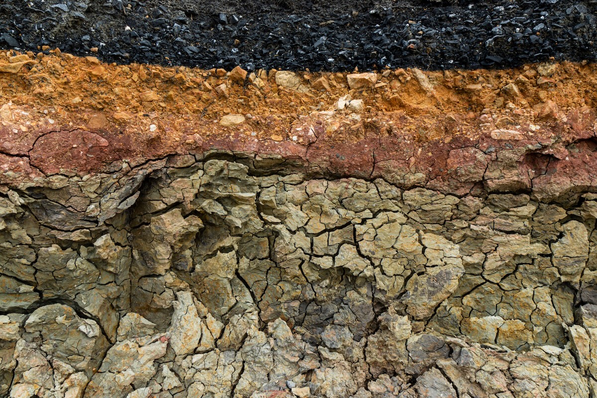 Die Schicht von Asphalt Straße mit Boden und Felsen. Bild ohne Fokus.