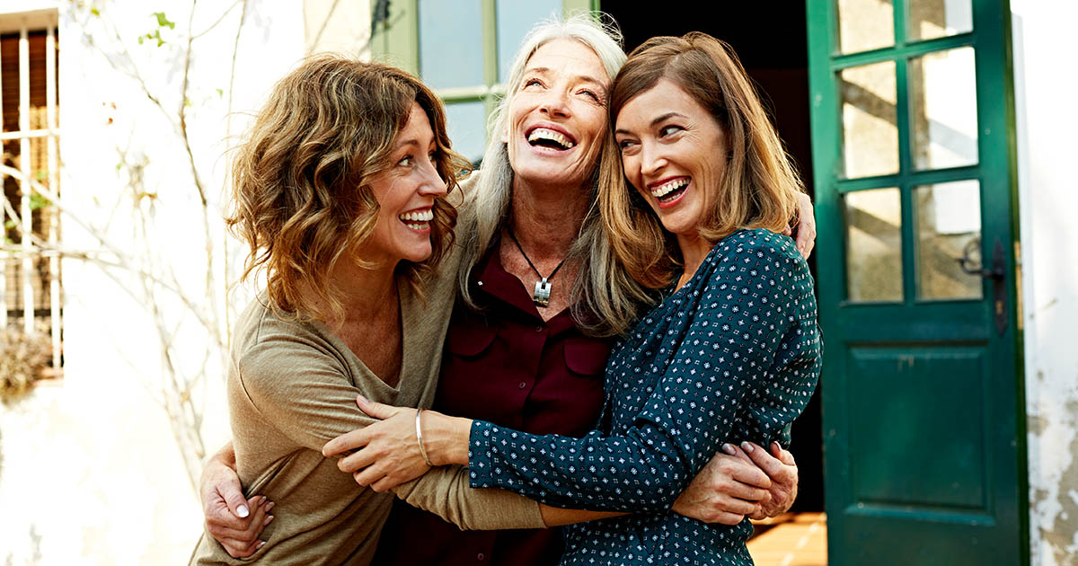 Mother and daughters embracing outdoors
