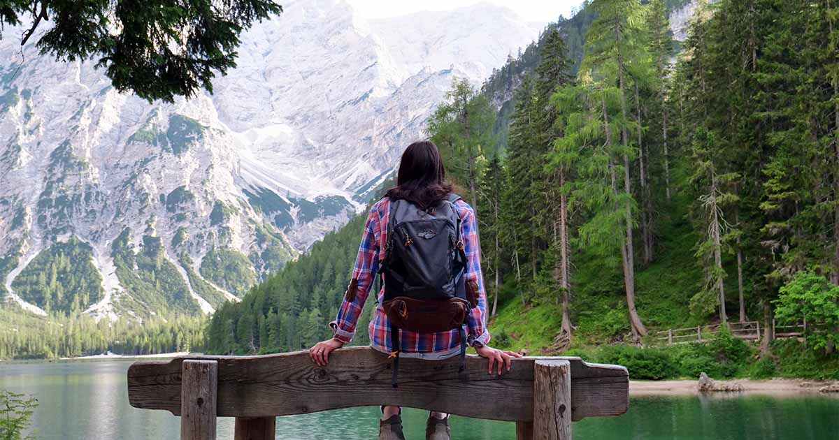 woman setting on wooden ledge looking at mountains