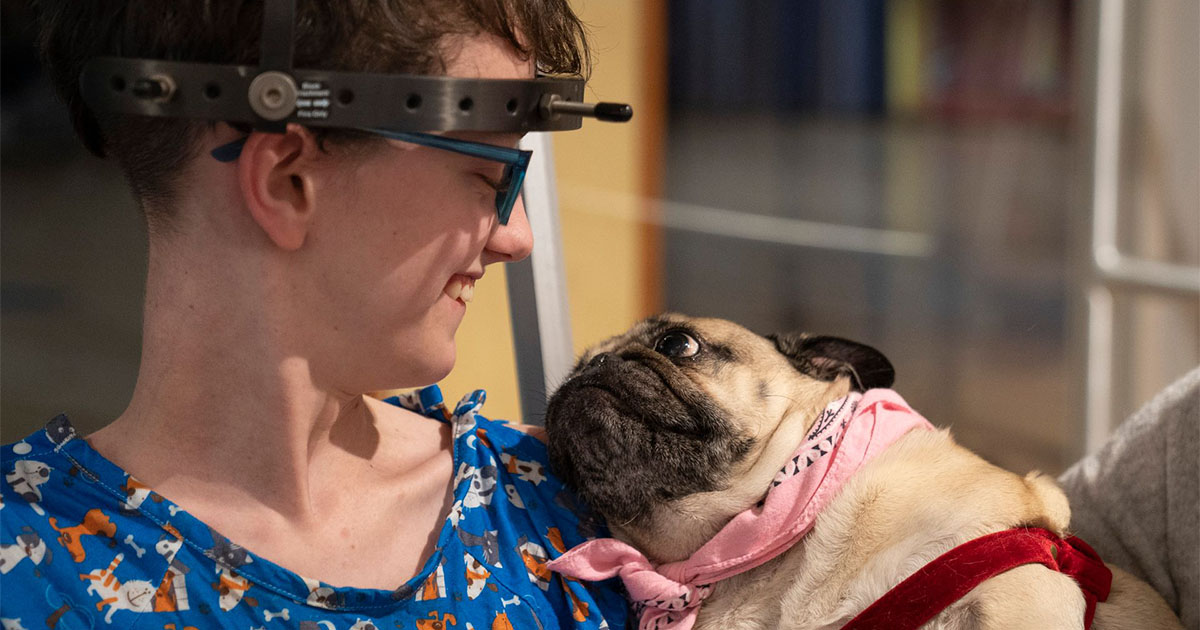 woman holding doug the pug in arms