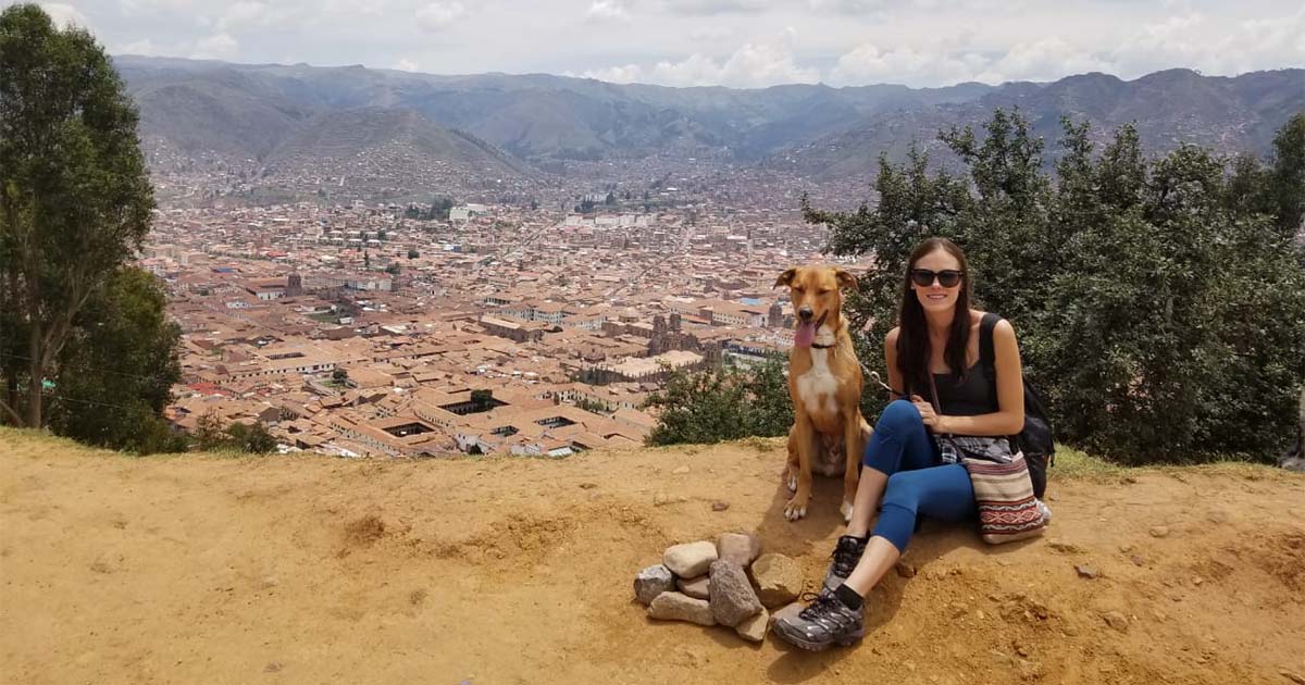woman sitting pet dog on trek