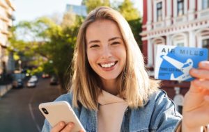 woman holding air miles rewards card
