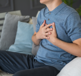 Herzinfarkt, Mann mit Brustschmerzen zu Hause Leid, Gesundheitskonzept