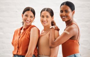 Covid-Impfungen oder Grippe schossen in Mädchen Freundschaften, Freundschaft und Jugendliche lächeln. Porträt einer glücklichen und vielfältigen Freundes-Gruppe, die zusammen gute Gesundheitsgewohnheiten praktiziert