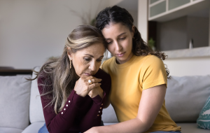 Traurig junge erwachsene lateinische Tochter tröstend depressive ältere Mutter zu Hause, tröstend, Umarmung gestresst aufgeregt Mutter, sitzen nah, geben Trost, Empathie, Unterstützung auf schlechte Probleme