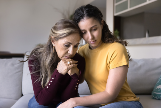 Traurig junge erwachsene lateinische Tochter tröstend depressive ältere Mutter zu Hause, tröstend, Umarmung gestresst aufgeregt Mutter, sitzen nah, geben Trost, Empathie, Unterstützung auf schlechte Probleme