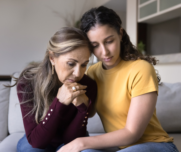 Traurig junge erwachsene lateinische Tochter tröstend depressive ältere Mutter zu Hause, tröstend, Umarmung gestresst aufgeregt Mutter, sitzen nah, geben Trost, Empathie, Unterstützung auf schlechte Probleme