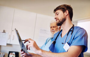 Klinik, Diskussion und Krankenschwester mit Röntgen von Mann für Diagnose, Untersuchung und medizinische Beurteilung. Seniorenpatientin, Menschen und Gesundheitswesen mit radiologischer Untersuchung auf Prostatakrebs, Behandlung oder Bewertung