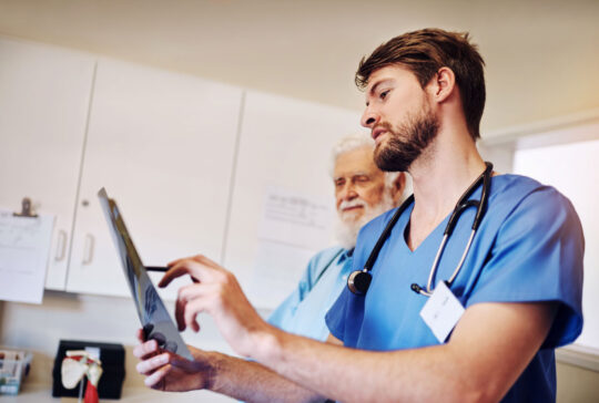 Klinik, Diskussion und Krankenschwester mit Röntgen von Mann für Diagnose, Untersuchung und medizinische Beurteilung. Seniorenpatientin, Menschen und Gesundheitswesen mit radiologischer Untersuchung auf Prostatakrebs, Behandlung oder Bewertung