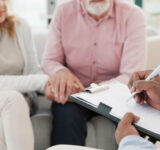 Händchen, Unterstützung und Seniorenpaar mit Therapeuten für Beratung, Hilfe und Unterstützung bei schwierigen Krisen- oder Krebsdiagnosen. Therapie, Depressionen und alte Menschen, die sich mit Psychologie-Experten beraten