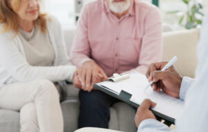 Händchen, Unterstützung und Seniorenpaar mit Therapeuten für Beratung, Hilfe und Unterstützung bei schwierigen Krisen- oder Krebsdiagnosen. Therapie, Depressionen und alte Menschen, die sich mit Psychologie-Experten beraten