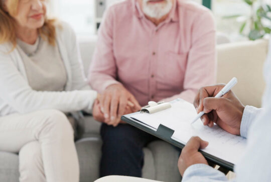 Händchen, Unterstützung und Seniorenpaar mit Therapeuten für Beratung, Hilfe und Unterstützung bei schwierigen Krisen- oder Krebsdiagnosen. Therapie, Depressionen und alte Menschen, die sich mit Psychologie-Experten beraten