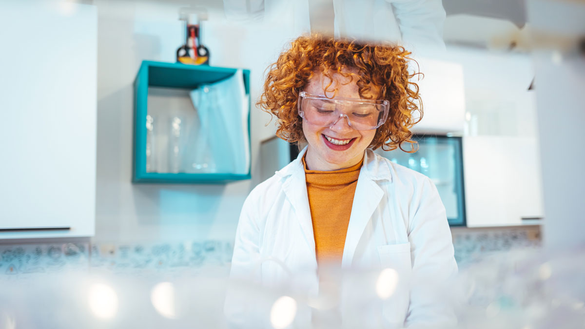 Scientist looking at test tube in the laboratory at the university. Laboratory assistant analyzing a sample. Scientist / researcher team conducting scientific research in science lab