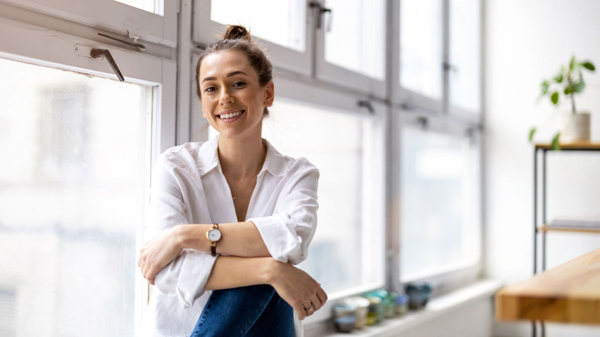 Portrait of a smiling creative woman in a modern loft space