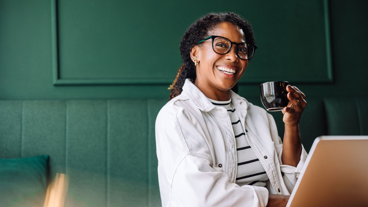 Woman smiling while working with laptop in a cafe