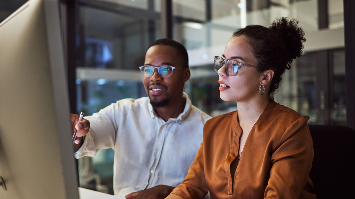 Night training, teamwork and employees planning marketing strategy in a dark office on computer at work. Corporate African man and woman talking about business collaboration during overtime together