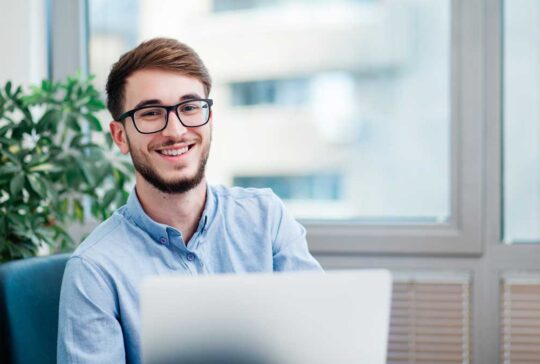 Young businessman in office working on laptop