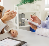 Zugeschnittene Ansicht des weiblichen Arztes aufmerksam zuhören Frau Patientin und Notizen während der Beratung. Arzt oder Kardiologe, der sich auf das Verständnis und die Behandlung von Fragen der Patientengesundheit konzentriert.