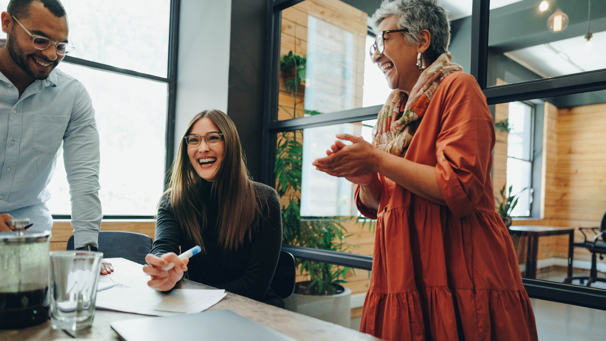 Group of successful businesspeople laughing cheerfully during an office meeting. Team of multicultural businesspeople collaborating in a creative workplace.