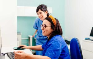 Two nurses using a computer in a x-ray room