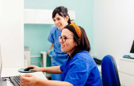 Two nurses using a computer in a x-ray room