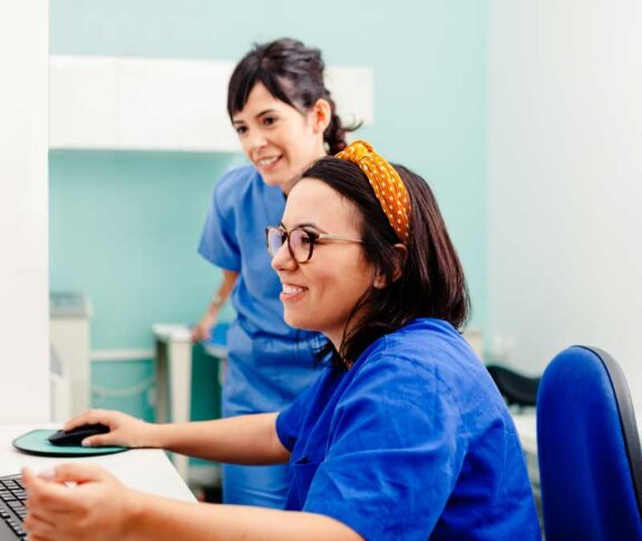 Two nurses using a computer in a x-ray room
