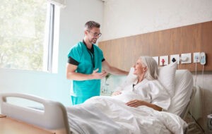 Surgeon Visiting And Talking With Mature Female Patient In Hospital Bed