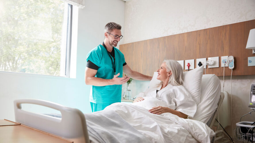 Surgeon Visiting And Talking With Mature Female Patient In Hospital Bed