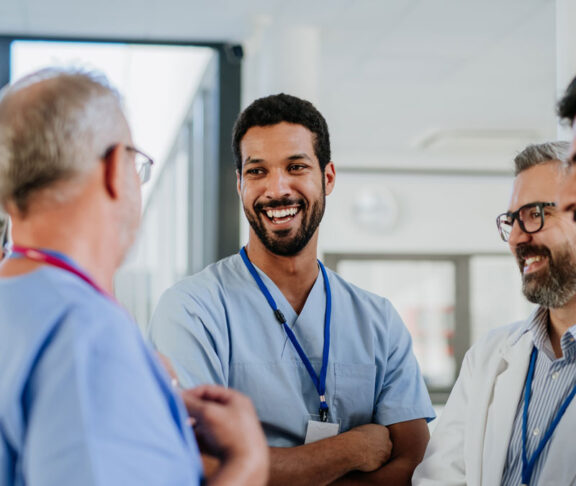 Team of doctors discussing something at hospital corridor.