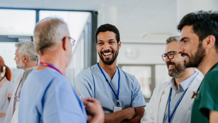 Team of doctors discussing something at hospital corridor.