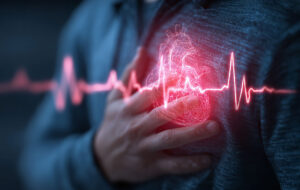 A person clutching their chest with a glowing heart symbol indicating pain or health issue