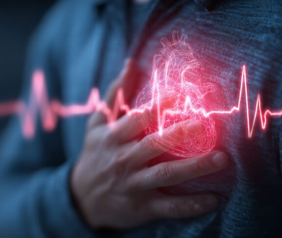 A person clutching their chest with a glowing heart symbol indicating pain or health issue