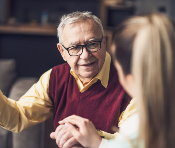 Home doctor is visiting senior man to check his health. Professional caregiver is assisting old man at his home