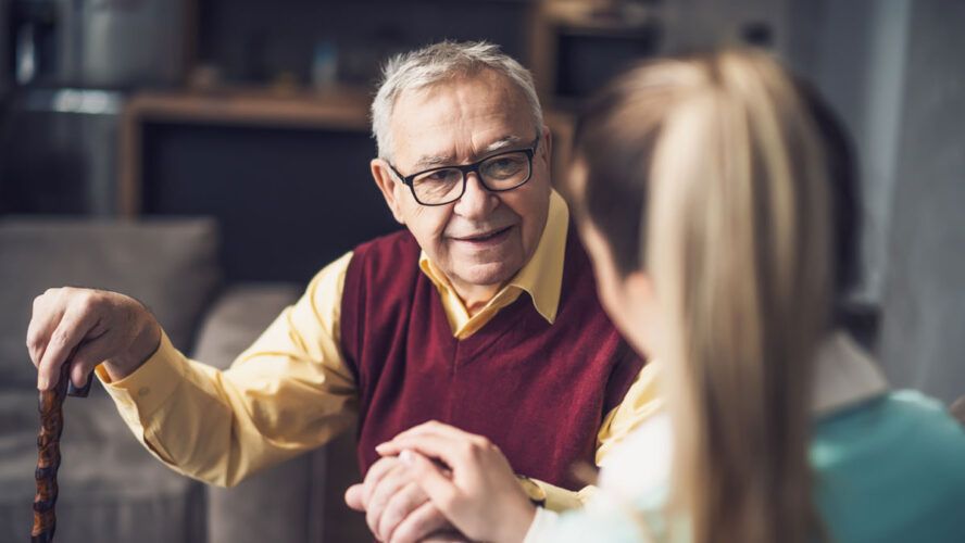 Home doctor is visiting senior man to check his health. Professional caregiver is assisting old man at his home
