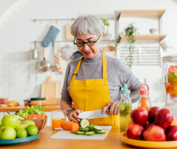 healthy asian aunt retired female woman enjoy making cook clean food breakfast for her healthy food lifestyle,smiling cheerful woman silver hair with tattoo prepare smoothie juice drink for her health