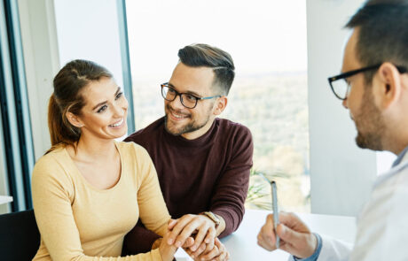 doctor woman man patient hospital care clinic couple young health female medical medicine discussion husband talking wife office family consultation happy appointment treatment