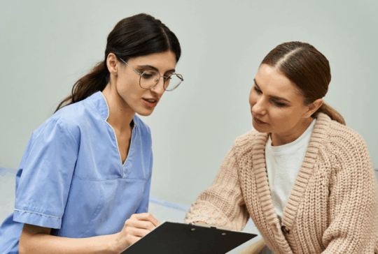 A professional gynecologist discusses health concerns with a patient in a contemporary clinic.