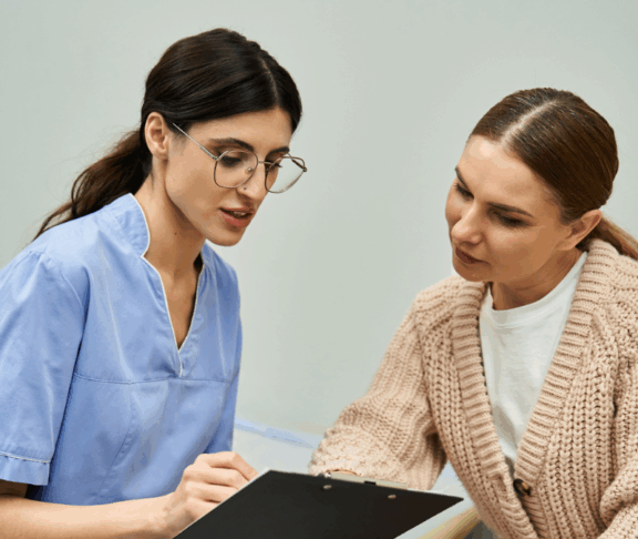 A professional gynecologist discusses health concerns with a patient in a contemporary clinic.